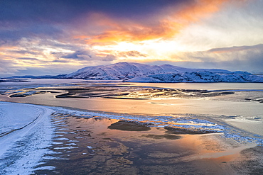 Sunset over the snow capped mountains and frozen sea in the pristine Tanamunningen Nature Reserve, Leirpollen, Finnmark, Arctic, Norway, Scandinavia, Europe