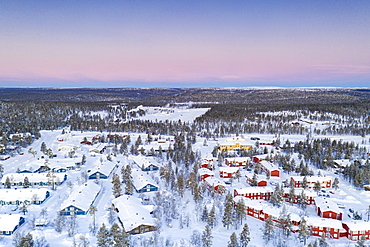 Aerial view of snow capped forest and Saariselka winter tourist resort at sunrise, Inari, Lapland, Finland, Europe