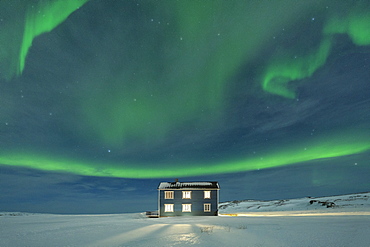 Northern Lights (Aurora borealis) on the illuminated house in the snow, Veines, Kongsfjord, Varanger Peninsula, Finnmark, Norway, Scandinavia, Europe