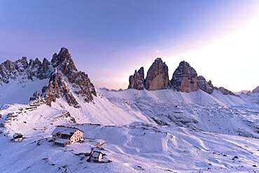 Sunset over Monte Paterno, Tre Cime di Lavaredo and Locatelli hut covered with snow, Sesto Dolomites, South Tyrol, Italy, Europe