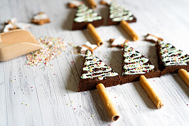 Homemade decorated chocolate brownies in shape of Christmas tree on wood table background, Italy, Europe