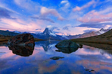 Glowing stars over Matterhorn mirrored in lake Stellisee at dusk, Zermatt, Valais canton, Switzerland, Europe