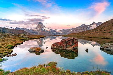 Pink sky at dawn over Matterhorn reflected in lake Stellisee, Zermatt, Valais Canton, Switzerland, Europe