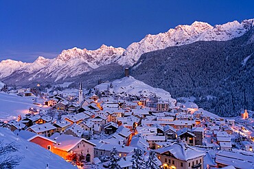 Traditional houses covered with snow during the winter dusk, Ardez, Engadine, Graubunden Canton, Switzerland, Europe