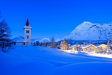 Alpine village of Maloja and Chiesa Bianca covered with snow at dusk, Bregaglia, Engadine, Graubunden Canton, Switzerland, Europe