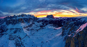 Clouds in the burning sky at sunset over Sassolungo and Sella Group mountains covered with snow, Dolomites, South Tyrol, Italy, Europe