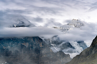 The Eiger and Monch mountain peaks in the cloudy sky, Mannlichen, Grindelwald, Bernese Oberland, Bern Canton, Switzerland, Europe