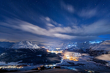 Starry winter sky over St. Moritz village and Upper Engadine covered with snow viewed from Muottas Muragl, Graubunden, Switzerland, Europe