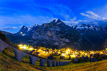 Steep viaduct of funicular above the illuminated village of Murren at night, Lauterbrunnen, Bernese Oberland, Switzerland, Europe