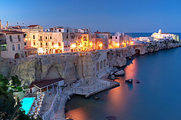 Illuminated pool of luxury resort by the sea at dusk in Vieste old town, Foggia province, Gargano, Apulia, Italy, Europe