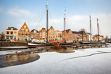 House facades and boats moored in the frozen canal of Spaarne river, Haarlem, Amsterdam district, North Holland, The Netherlands, Europe