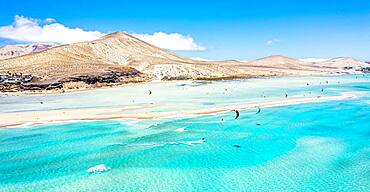 People kiteboarding on waves crashing on white sand of Sotavento beach, Jandia, Fuerteventura, Canary Islands, Spain, Atlantic, Europe