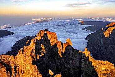 Clouds surrounding the rocky peak of Pico das Torres lit by sunset, Madeira island, Portugal, Atlantic, Europe