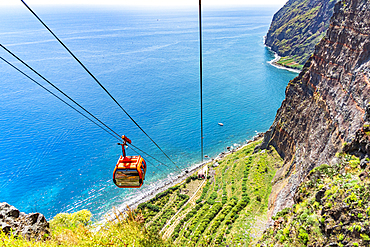 Elevated view of cable car Teleferico Do Rancho going down on steep crag to the ocean, Camara de Lobos, Madeira island, Portugal, Atlantic, Europe