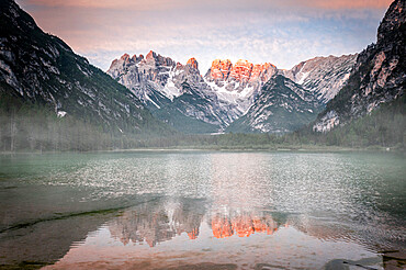 Popena group and Monte Cristallo mirrored in lake Landro (Durrensee) in the mist at dawn, Dolomites, South Tyrol, Italy, Europe