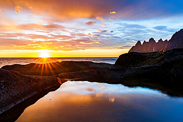 Midnight sun over the fjord and mountain peaks known as Devil's Teeth, Tungeneset viewpoint, Senja, Troms county, Norway, Scandinavia, Europe