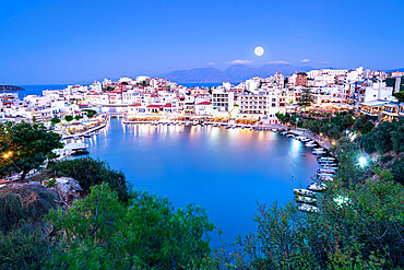 Moonlight over the old town of Agios Nikolaos and lake at dusk, Lasithi prefecture, Crete, Greek Islands, Greece, Europe