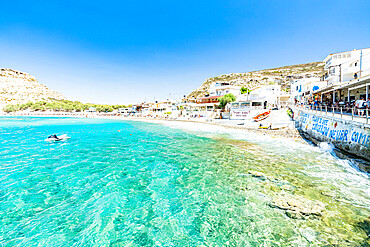 Beach of the seaside town resort of Matala washed by turquoise sea, Crete, Greek Islands, Greece, Europe