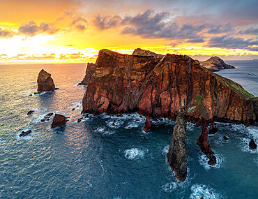 Burning sky at dawn on cliffs washed by ocean, Ponta do Rosto viewpoint, Sao Lourenco Peninsula, Madeira island, Portugal, Atlantic, Europe