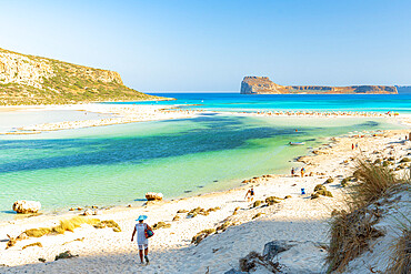 Tourists walking to the white sand beach surrounding Balos lagoon, Crete, Greek Islands, Greece, Europe