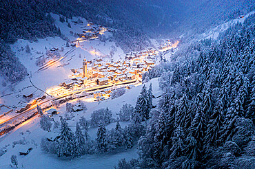 Trees covered with snow in the winter forest surrounding the alpine village at Christmas, Valgerola, Valtellina, Lombardy, Italy, Europe