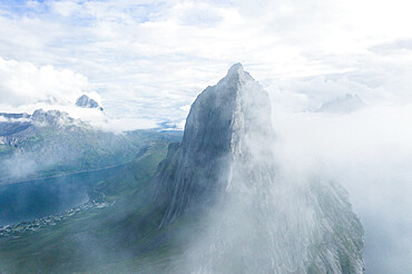 Aerial view of fog over the majestic Segla Mountain peak emerging from clouds, Senja island, Troms county, Norway, Scandinavia, Europe