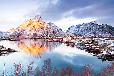 Red Rorbu cabins by the sea with Mount Olstind in the background, Reine Bay, Lofoten Islands, Norway, Scandinavia, Europe