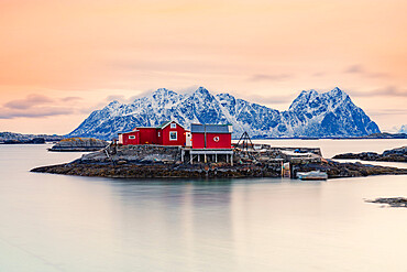 Isolated red fishermen's cabins on rocks in the cold sea at sunset, Svolvaer, Nordland county, Lofoten Islands, Norway, Scandinavia, Europe