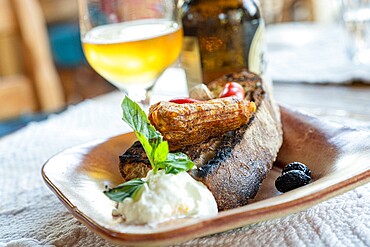 Greek appetizer of stuffed zucchini flowers served with bruschetta and tzatziki sauce in wood bowl, Crete, Greek Islands, Greece, Europe