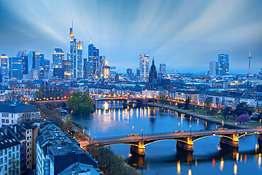 Long exposure of clouds at dusk over the illuminated city skyline and Ignatz Bubis bridge, Frankfurt am Main, Hesse, Germany Europe