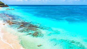 Woman floating in the crystal sea on idyllic tropical beach, overhead view, Antigua, Leeward Islands, Caribbean, West Indies