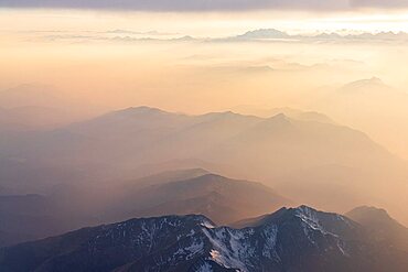 Mist at sunset over the majestic Lepontine Alps and Monte Rosa in the clouds, aircraft point of view, Switzerland