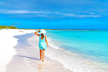 Beautiful woman walking on idyllic beach washed by Caribbean Sea, Barbuda, Antigua and Barbuda, West Indies, Caribbean, Central America