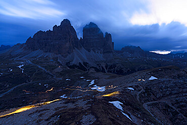 Clouds at dusk in the foggy sky over the majestic rocks of Tre Cime di Lavaredo, Dolomites, South Tyrol, Italy, Europe