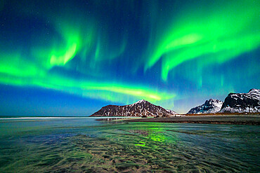 Skagsanden beach under the bright Northern Lights (Aurora Borealis) sky reflected in the sea, Ramberg, Nordland county, Lofoten Islands, Norway, Scandinavia, Europe