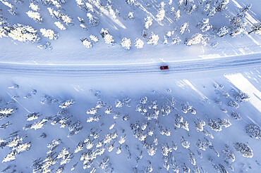 Overhead view of car driving on winding road in the winter forest covered with snow, Kangos, Norrbotten County, Lapland, Sweden, Scandinavia, Europe