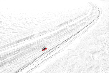 Aerial view of car traveling on empty ice road on the frozen sea, Lulea, Norrbotten County, Lapland, Sweden, Scandinavia, Europe