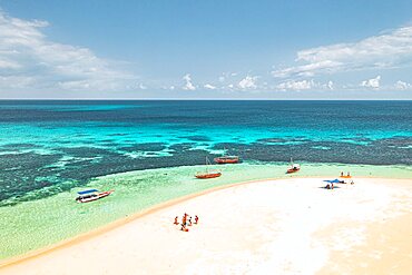 Tourists having fun on idyllic beach washed by the crystal water of Indian Ocean, aerial view, Kwale Island, Zanzibar, Tanzania