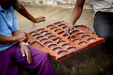 Men playing the famous Bao board game in the street, Stone Town, Zanzibar, Tanzania, East Africa, Africa