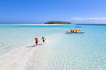 Cheerful man and woman having fun chasing each others on a tropical beach, aerial view, Zanzibar, Tanzania, East Africa, Africa