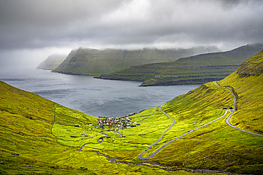 Storm clouds over the coastal village of Funningur along the fjord, Eysturoy Island, Faroe Islands, Denmark, Europe