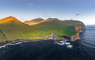 Aerial panoramic view of the village of Gjogv on cliffs washed by the ocean, Eysturoy Island, Faroe Islands, Denmark, Europe