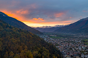 Larch tree woods on mountains surrounding Morbegno town at sunset in autumn, Valtellina, Sondrio province, Lombardy, Italy, Europe