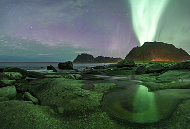 Green lights of Aurora Borealis (Northern Lights) glowing over mountains and Uttakleiv beach, Vestvagoy, Lofoten Islands, Nordland, Norway, Scandinavia, Europe