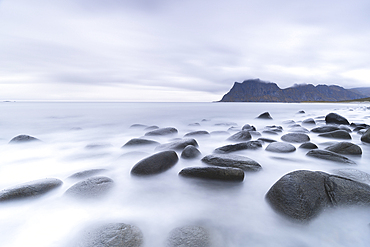 Clouds at dusk over rocks washed by the Arctic sea at Uttakleiv beach, Vestvagoy, Lofoten Islands, Nordland, Norway, Scandinavia, Europe