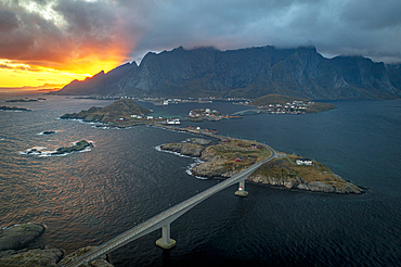 Aerial view of a bridge crossing the fjord under a dramatic sky at sunset, Reine Bay, Lofoten Islands, Nordland, Norway, Scandinavia, Europe