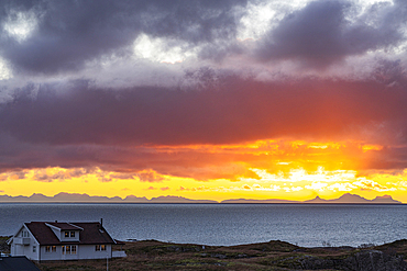 Lone traditional house by the sea under a dramatic sky at dawn, Reine, Lofoten Islands, Nordland, Norway, Scandinavia, Europe