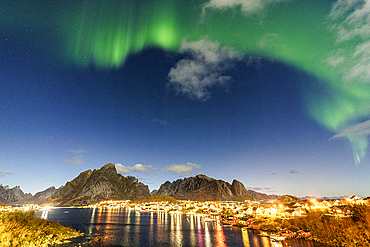 Illuminated harbor of Reine reflected in the cold arctic sea during the Aurora Borealis (Northern Lights), Reine, Lofoten Islands, Nordland, Norway, Scandinavia, Europe