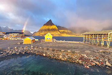 Aerial panoramic view of traditional rorbu and Olstind peak under the rainbow, Sakrisoy, Reine, Lofoten Islands, Nordland, Norway, Scandinavia, Europe