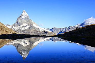 Hikers admiring the Matterhorn reflected in Lake Stellisee, Zermatt, Canton of Valais, Pennine Alps, Swiss Alps, Switzerland, Europe